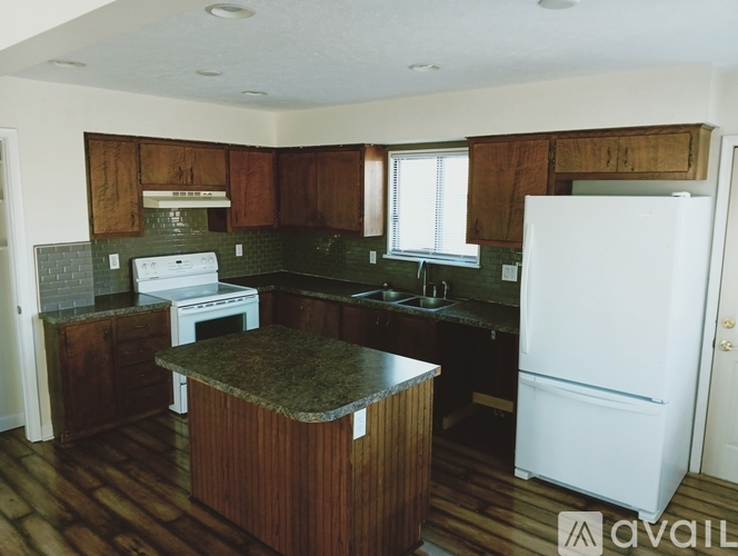 A kitchen with a white fridge and wooden cabinets.