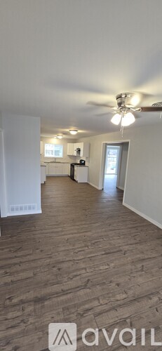 A room with wooden flooring and a ceiling fan.