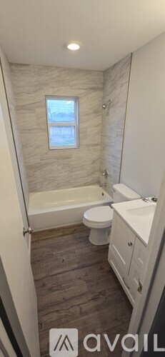A bathroom with a tub, toilet, and sink.