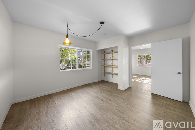 A room with wooden flooring and a hanging light fixture.