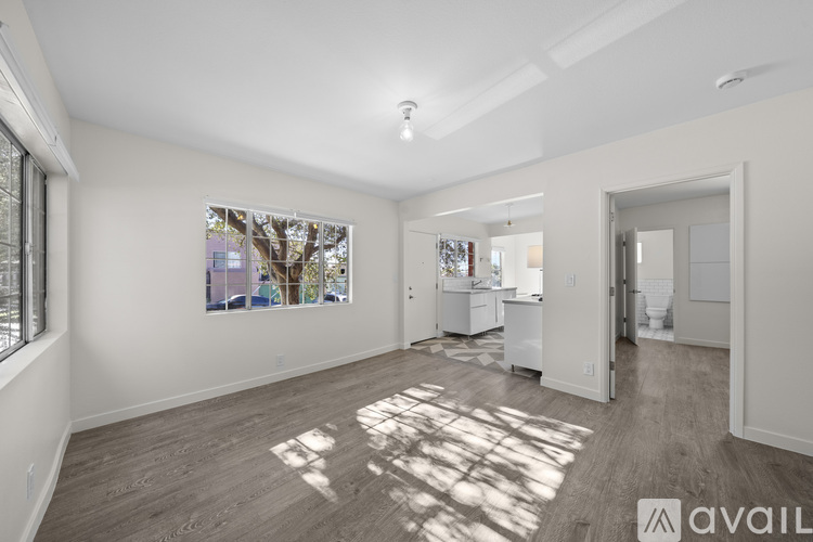 A spacious room with a large window and a painting on the wall.