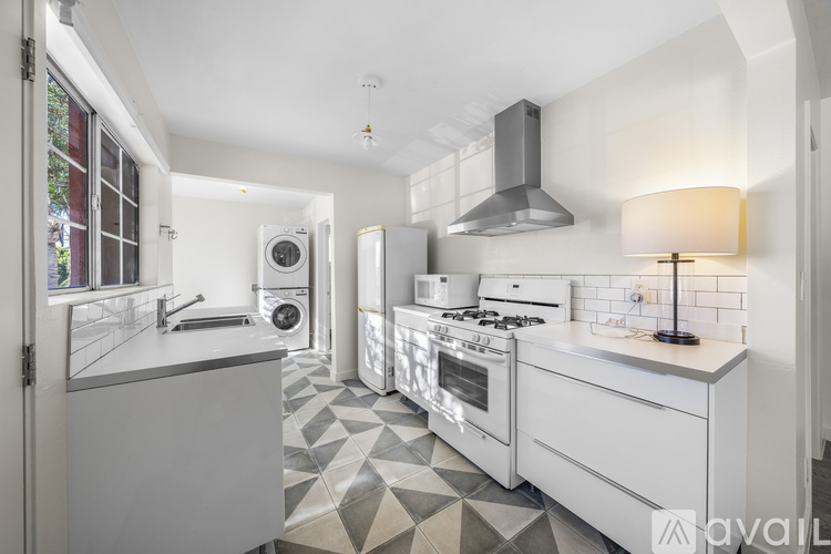 A modern kitchen with white appliances and a tiled floor.
