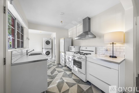 A modern kitchen with white appliances and a tiled floor.