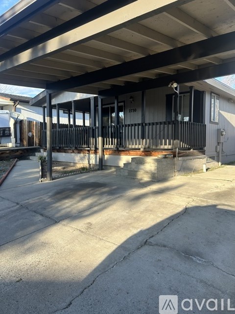 A building with a porch and a sign that says "avail" on the bottom right.