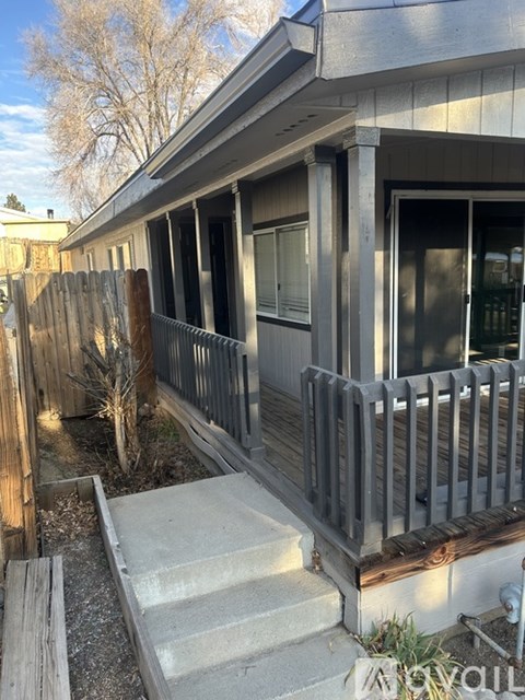 A house with a grey roof and a wooden fence.