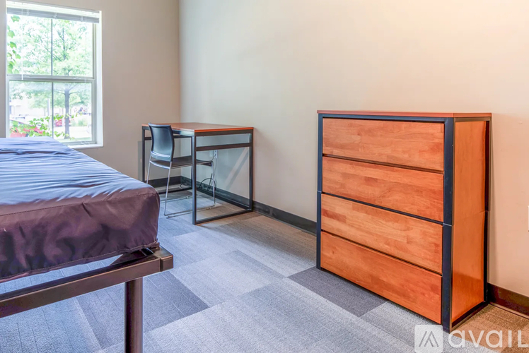 A bedroom with a bed, desk, and chair.