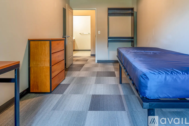 A bedroom with a bed, dresser, and mirror.
