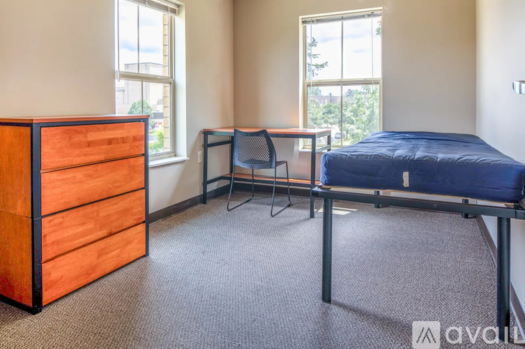 A bedroom with a bed, desk, and chair.