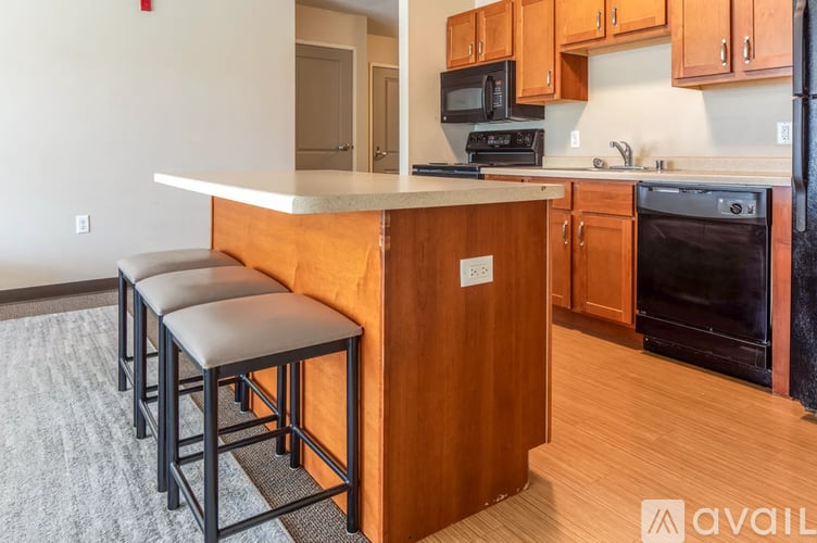 A kitchen with a white countertop and wooden cabinets.