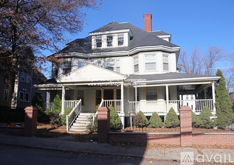 A large house with a porch and a sign that says "Supreme Realty Corporation".