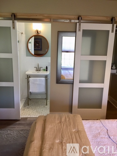 A bathroom with a sink, mirror, and shower.