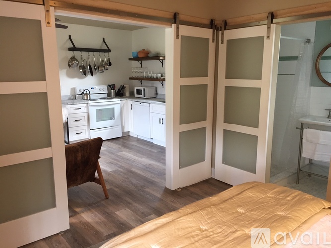 A kitchen with a table and chairs is visible through a sliding glass door.