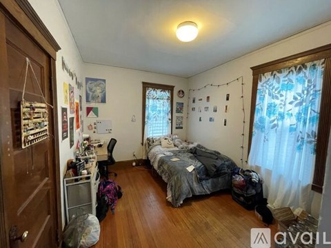 A bedroom with a bed, desk, and chair.