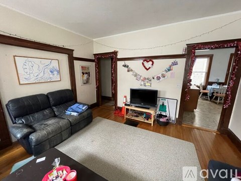 A living room with a black leather sofa and a television.