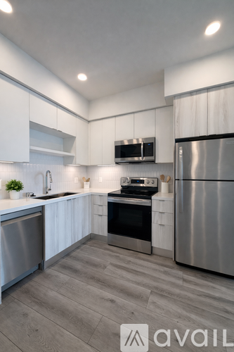 A modern kitchen with stainless steel appliances and white cabinets.