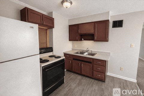 A kitchen with brown cabinets and a white refrigerator.