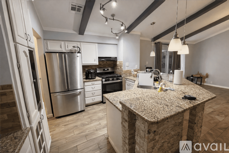 A kitchen with a granite countertop and stainless steel appliances.