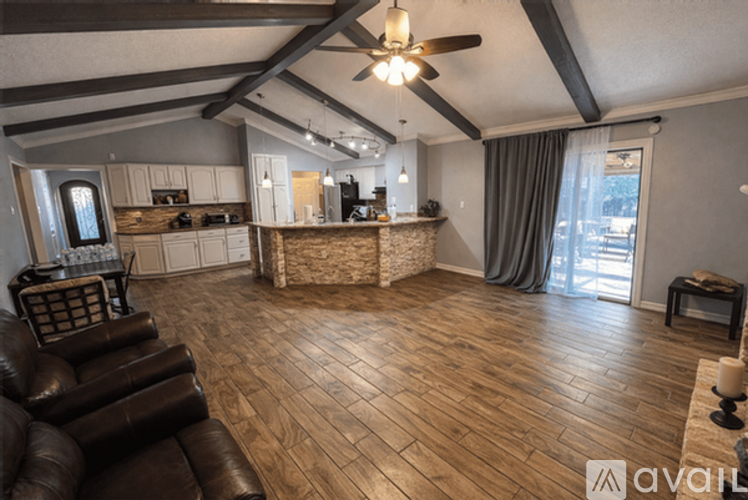 A living room with a brown leather chair and wooden flooring.