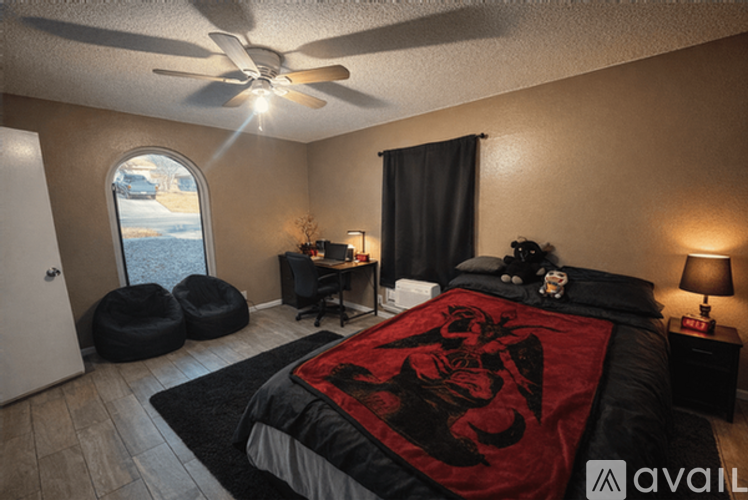 A bedroom with a large bed and a ceiling fan.