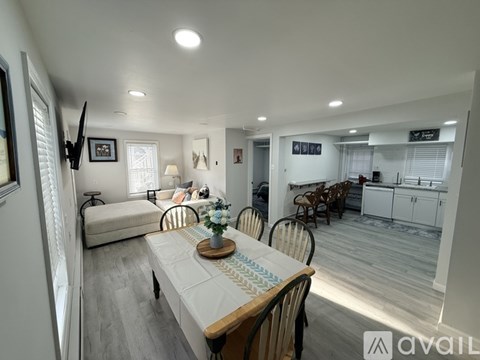 A dining room with a table set for four and chairs around it.