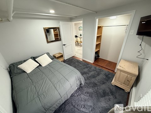 A bedroom with a bed, a nightstand, and a television.