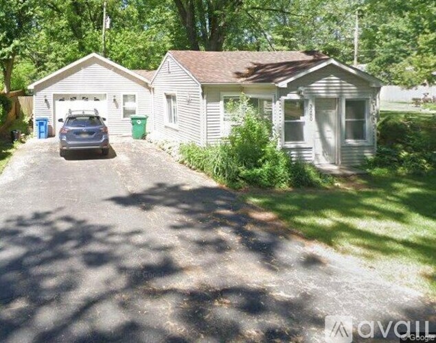 A house with a driveway and a car parked in front.