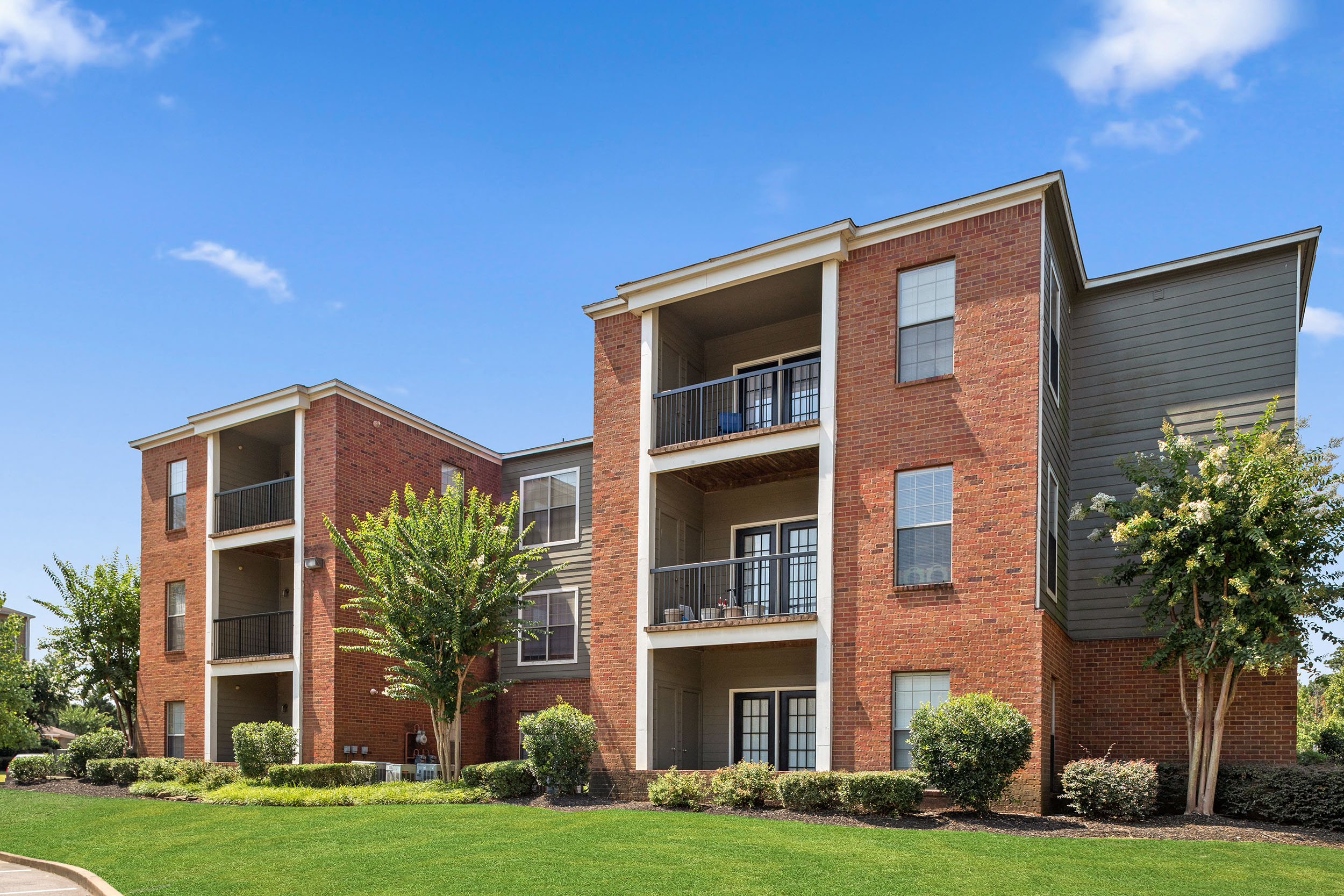 Exterior of brick apartment building with private patios and balconies