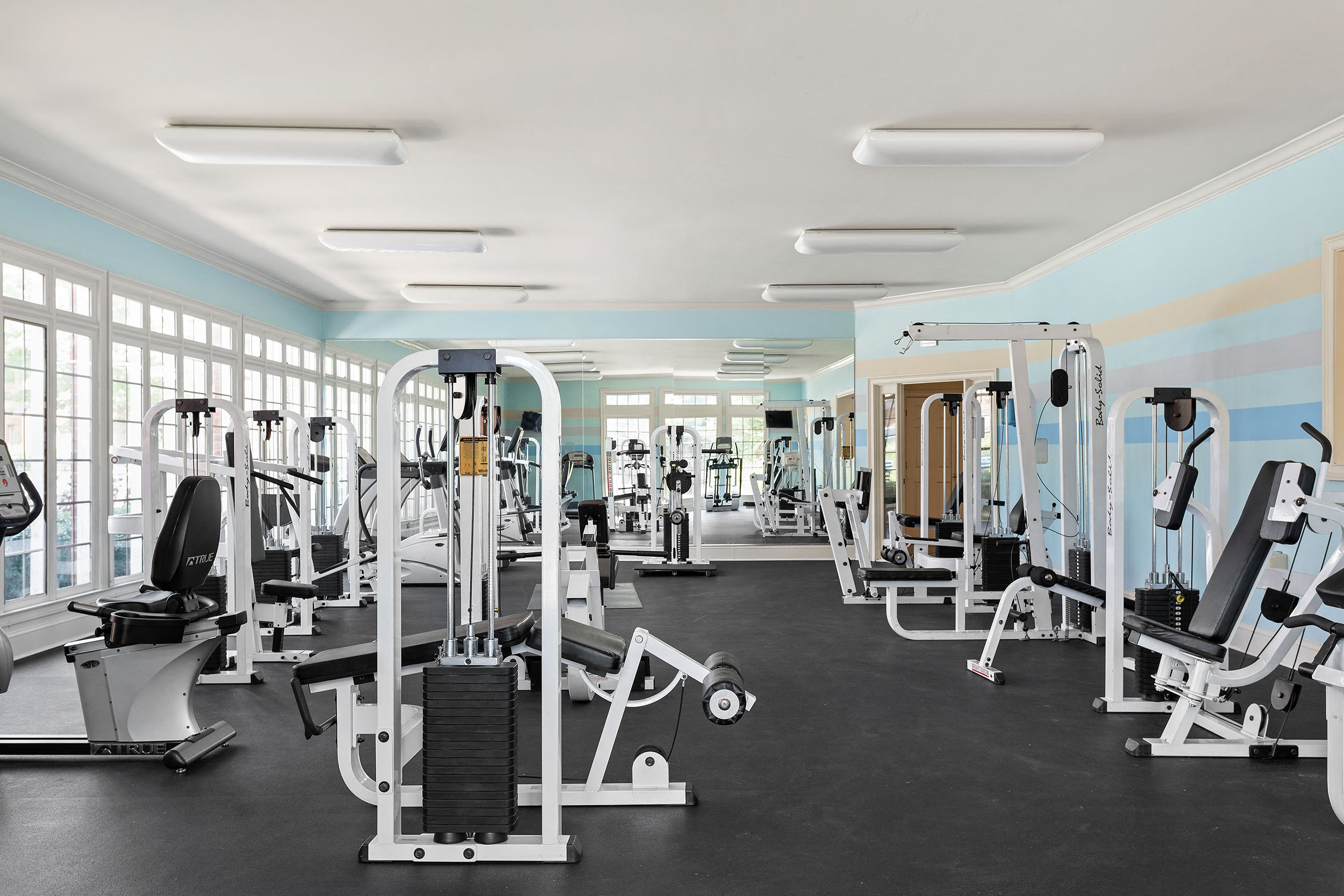 Large apartment fitness center with cardio machines and strength training equipment