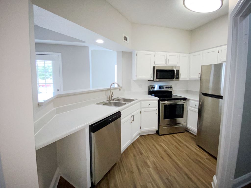 Newly renovated kitchen with white cabinets and stainless steel appliances in Cordova apartment for rent