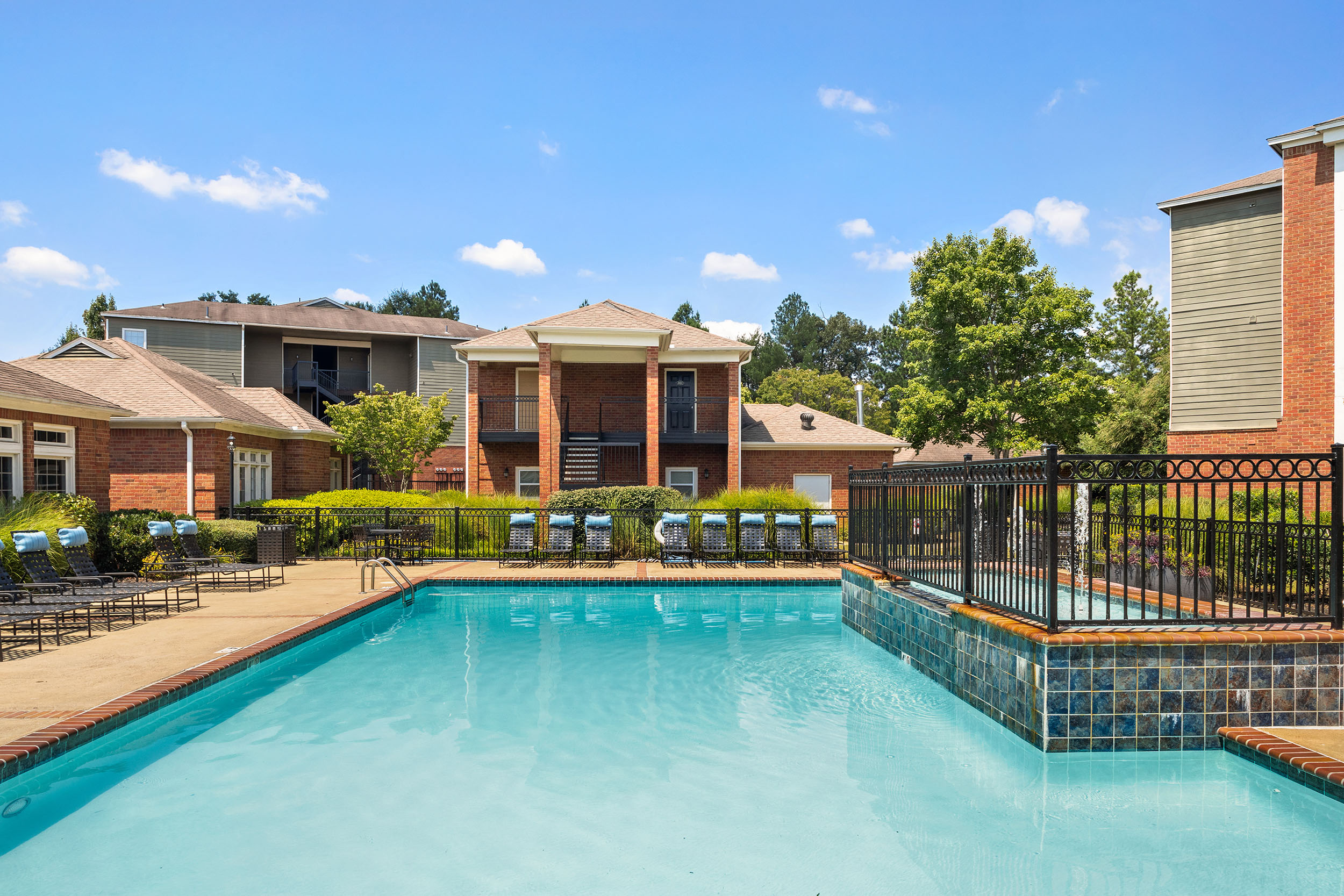 Large, outdoor swimming pool with poolside lounge chairs for residents of Cordova apartments