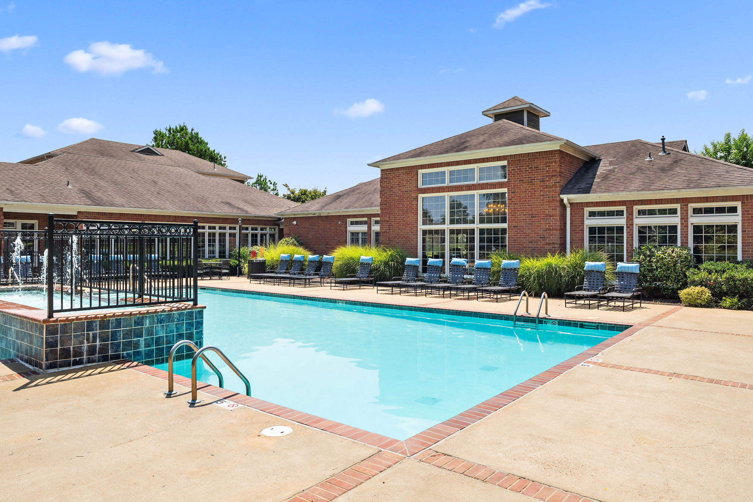 Lounge chairs next to outdoor swimming pool at Walnut Hill Apartment Homes for rent