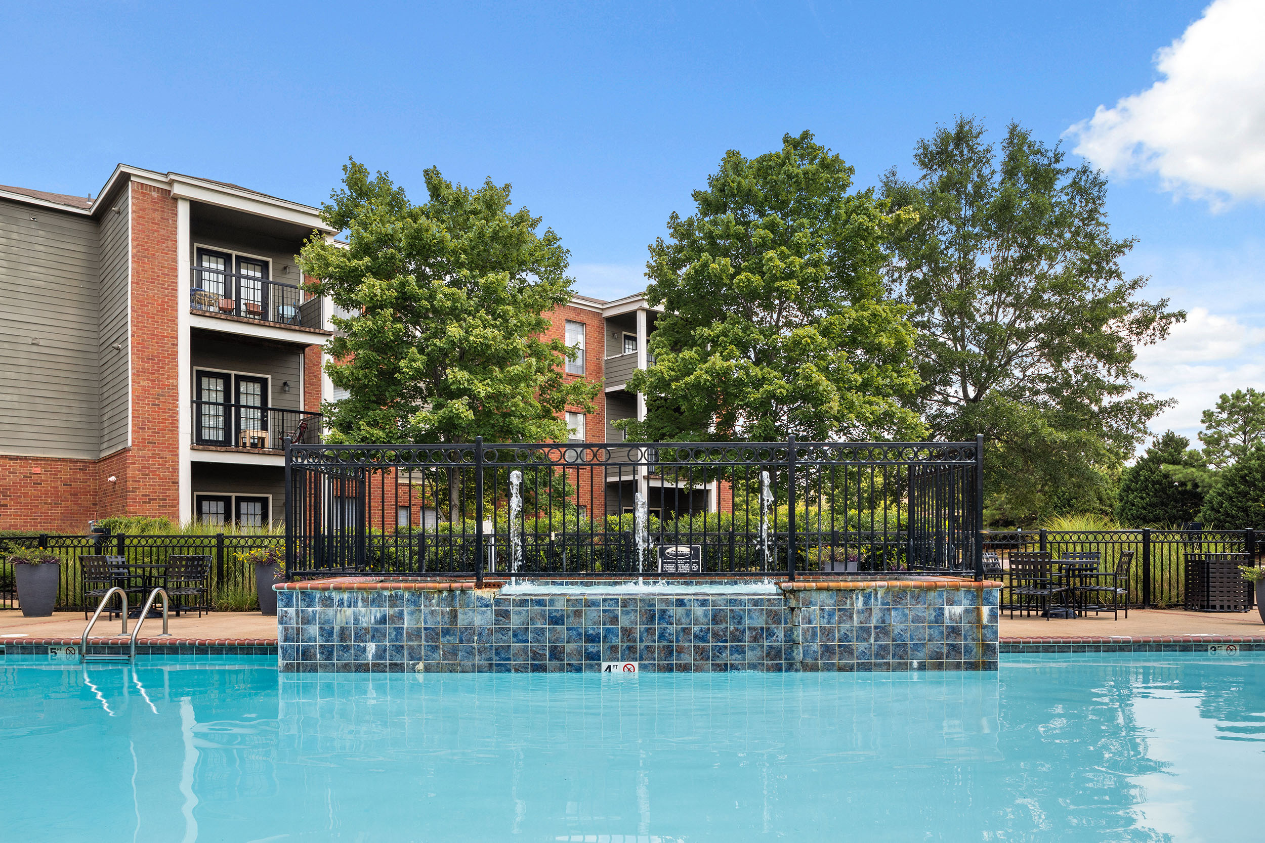 Resort-style swimming pool at Cordova apartments for rent with shade trees