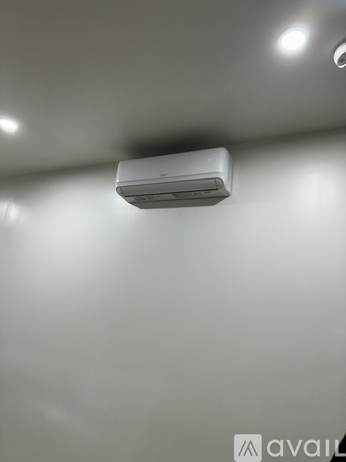 A wall-mounted air conditioner is installed on a white wall.
