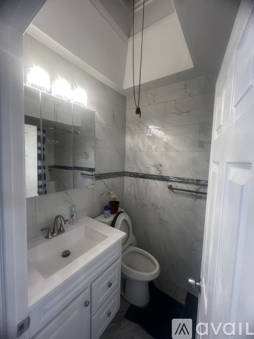 A bathroom with a white sink and toilet.