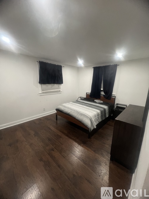 A bedroom with a bed, nightstand, and window.