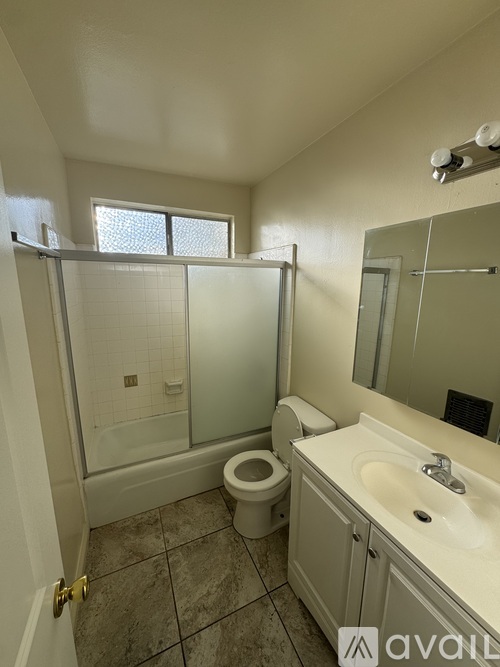 A bathroom with a toilet, sink, and shower.