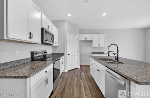 A kitchen with white cabinets and a granite countertop.