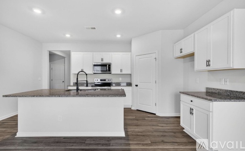 A kitchen with white cabinets and a granite countertop.
