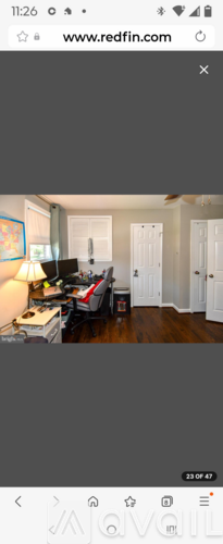 A room with a white door and a painting on the wall.