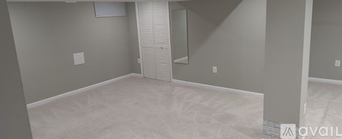 A room with a white floor and walls, and a door with blinds.