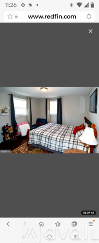 A bedroom with a bed and a chair.