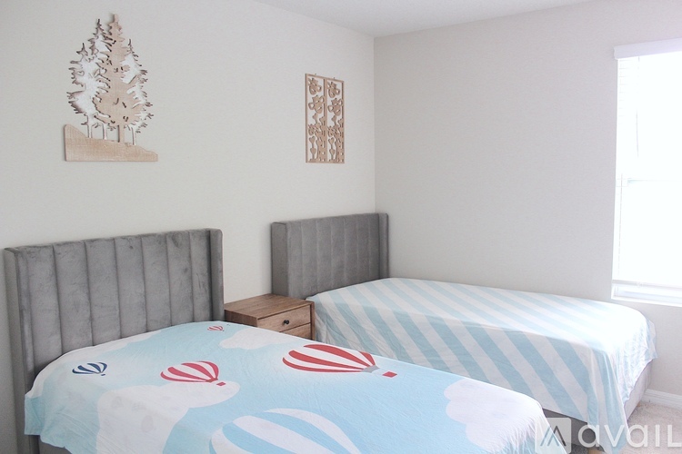 A bedroom with two beds and a wooden nightstand.