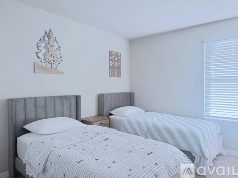 A bedroom with two beds and a wooden nightstand.