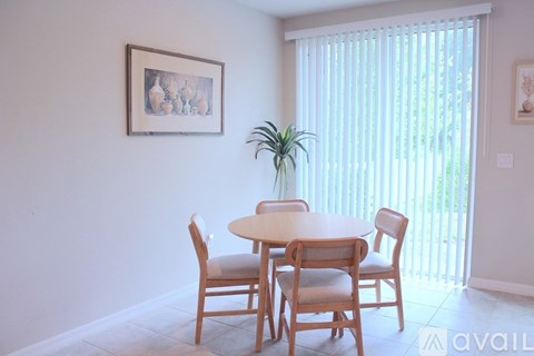 A dining room with a table and chairs.