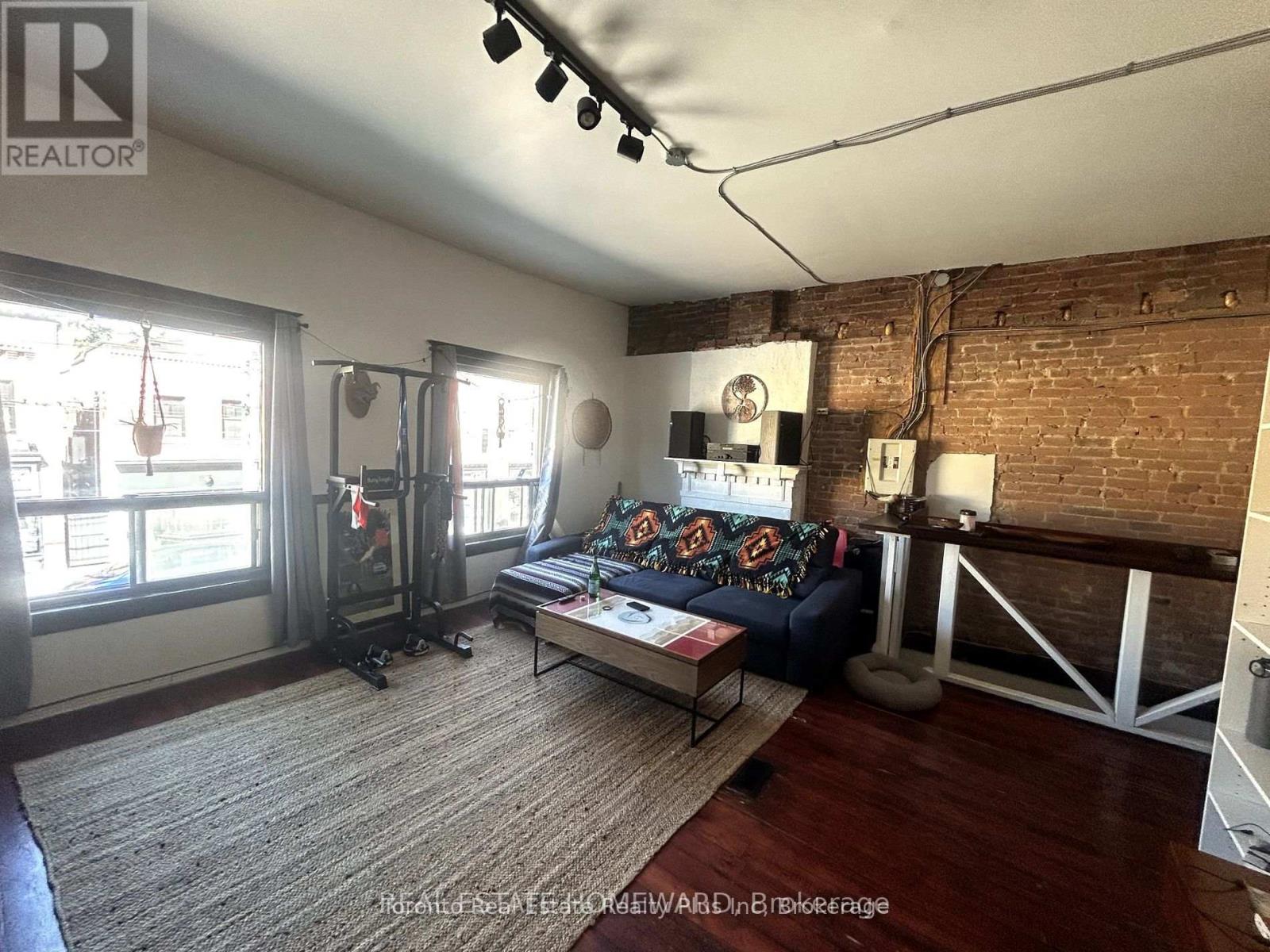 A living room with a couch, a coffee table, and a fireplace.