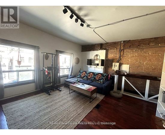A living room with a couch, a coffee table, and a fireplace.