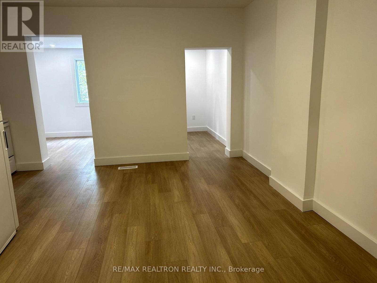 A room with wooden flooring and white walls.