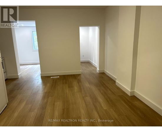 A room with wooden flooring and white walls.