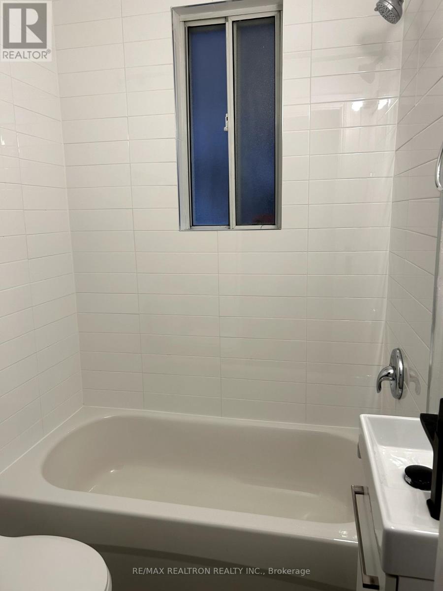 A white bathroom with a tub, toilet, and sink.