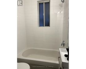 A white bathroom with a tub, toilet, and sink.